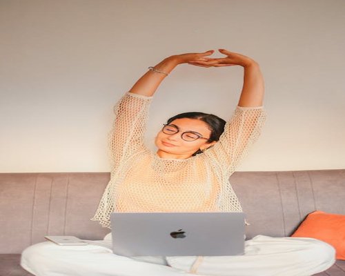 A person stretching their arms while sitting at a desk