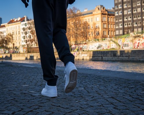 A person wearing comfortable shoes walking on a city sidewalk